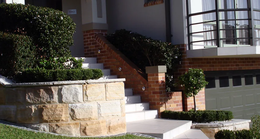 Sandstone entrance steps through a planted slope