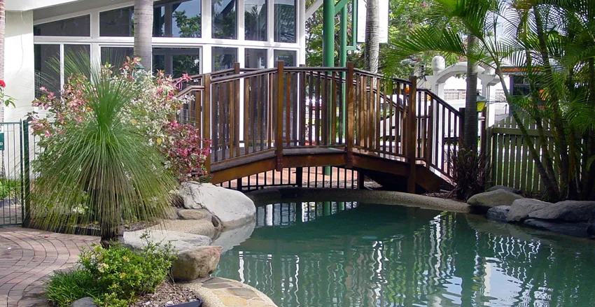 Garden pool crossed by a timber bridge